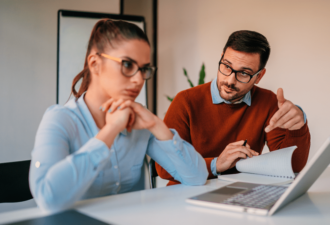 A manager engaged in a supportive one-to-one conversation with a colleague, demonstrating early intervention leadership through attentive listening and open dialogue to address team member needs before issues escalate.